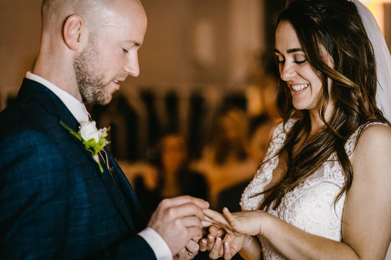 Groom placing the wedding ring on the bride's finger during the ceremony